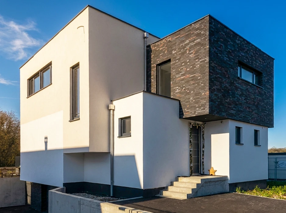 Maison contemporaine à toit plat, façade bicolore combinant enduit blanc lisse et parement en briques slim multicolores anthracite