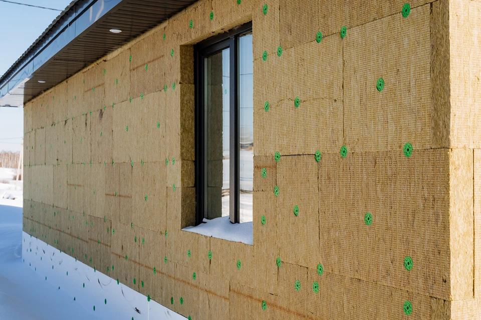 Isolation de la maison avec laine minérale, matériaux éco-respectueux, façade du bâtiment, rénovation d'une maison de campagne, fenêtre sur la rue, isolation thermique