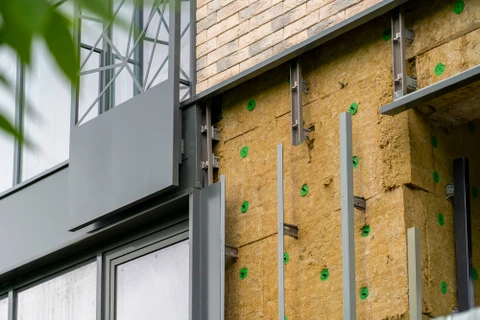 Chantier de construction extérieur montrant l'installation d'isolation thermique sur façade