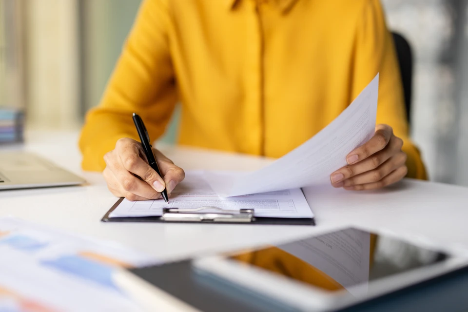 Un petite modèle de maison moderne sur un bureau, entouré de éléments d'énergie verte comme des éoliennes et des panneaux solaires, de rénovations durables et de diverses chambres dans un design respectueux de l'environnement