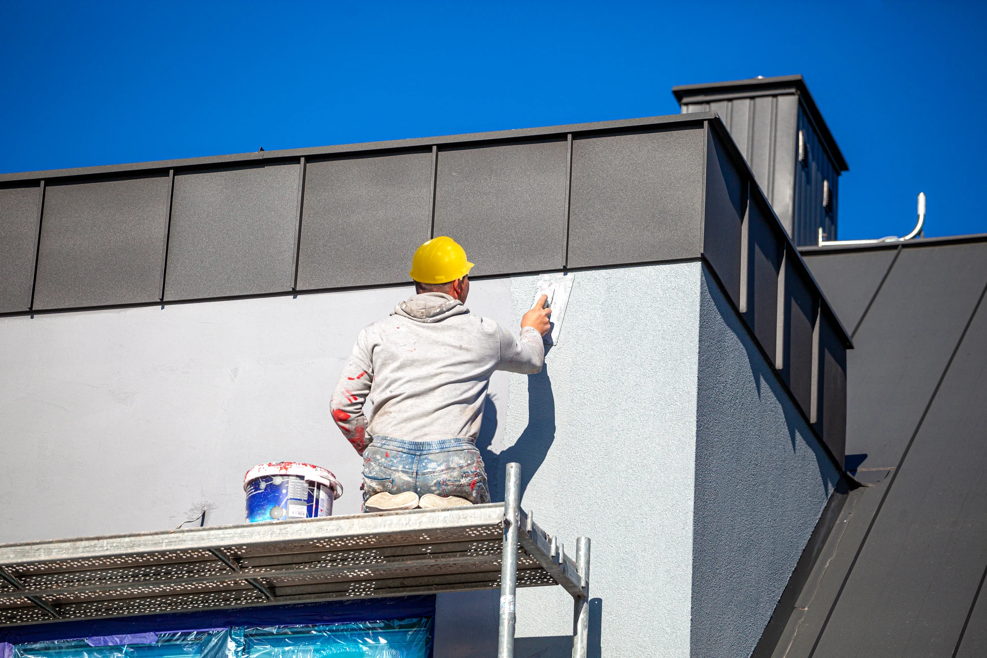 Chantier de rénovation en extérieur avec échafaudage complet recouvrant la façade d'un bâtiment
